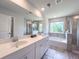 Modern bathroom with a dual sink vanity, a soaking tub, and a glass-enclosed shower at 415 W Respite Ln, Summerville, SC 29483