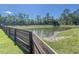Scenic view of the pond with a fenced yard, enhanced by a clear sky and lush trees at 415 W Respite Ln, Summerville, SC 29483