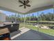 Enclosed patio featuring an outdoor grill, seating, and a tranquil view of the backyard and pond at 415 W Respite Ln, Summerville, SC 29483
