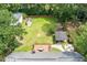 Aerial view of the large fenced in backyard featuring a large deck, outdoor kitchen, a fire pit, and ample green space at 44 S Basilica Ave, Hanahan, SC 29410