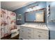 Fun bathroom featuring a double sink vanity, rainbow shower curtain and blue walls at 44 S Basilica Ave, Hanahan, SC 29410