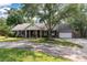 Charming brick home with a large front yard, mature trees and a circular driveway provides shade and curb appeal at 44 S Basilica Ave, Hanahan, SC 29410