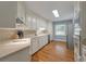 Bright kitchen featuring hardwood floors, white cabinetry, stainless steel appliances, and ample countertop space at 44 S Basilica Ave, Hanahan, SC 29410