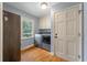 Well-lit laundry room featuring modern appliances, storage, and hardwood floors at 44 S Basilica Ave, Hanahan, SC 29410