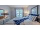 Comfortable bedroom featuring a striped bedspread, two bedside tables with lamps, and a framed mirror at 45 Sycamore Ave # 611, Charleston, SC 29407
