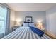 Comfortable bedroom featuring a striped bedspread, two bedside tables with lamps, and a bright window at 45 Sycamore Ave # 611, Charleston, SC 29407