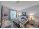 Cozy bedroom with a striped bedspread, two bedside tables with lamps, and a window with patterned curtains at 45 Sycamore Ave # 611, Charleston, SC 29407