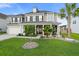 Inviting two-story home with a manicured lawn, mature trees, and a charming front porch with rocking chairs at 451 Spectrum Rd, Summerville, SC 29486