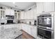 Bright, modern kitchen featuring white cabinets, granite countertops, and stainless steel double ovens at 451 Spectrum Rd, Summerville, SC 29486