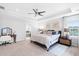 Bright main bedroom features tray ceiling, ceiling fan, bedside table, and ensuite bathroom at 451 Spectrum Rd, Summerville, SC 29486