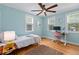 Bright bedroom with light blue walls, hardwood floors, and desk space at 4932 N Rhett Ave, North Charleston, SC 29405