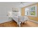 Stylish bedroom with bright walls, wood floors, large windows, ceiling fan and neutral-toned bedding at 4932 N Rhett Ave, North Charleston, SC 29405