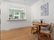 Charming dining area with wood floors, a rustic table and chairs, and a view to another bright, plant-filled room at 4932 N Rhett Ave, North Charleston, SC 29405