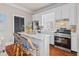 Bright eat-in kitchen with white cabinetry, stainless appliances, bar stool seating, and marble countertops at 5 1/2 Kracke St # A, Charleston, SC 29403