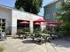 Outdoor seating area featuring picnic tables, umbrellas, and lush greenery for a relaxed dining experience at 5 1/2 Kracke St # A, Charleston, SC 29403