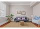 Well-lit sitting room with gray sofa, neutral rug, and a view of the backyard at 5 1/2 Kracke St # A, Charleston, SC 29403