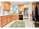 Well-lit kitchen featuring warm wood cabinetry, light countertops, black appliances and an eat-in dining area at 5359 Curtisston Ct, North Charleston, SC 29418