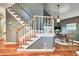 Bright staircase with white railings and wood trim, leading to dining area featuring an artful chandelier at 5359 Curtisston Ct, North Charleston, SC 29418