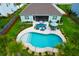 An aerial view of a backyard pool with turquoise water, lounge furniture, and decorative landscaping at 5509 Alpine Dr, Summerville, SC 29483