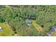 Aerial view of a secluded home with a green roof, nestled amidst lush trees and a private pond at 5519 Jefferies Hwy, Walterboro, SC 29488