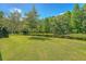 Scenic backyard view featuring a lush green lawn, tranquil pond, and mature trees at 5519 Jefferies Hwy, Walterboro, SC 29488