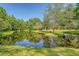 Picturesque pond view with a lush island, bench seating, and mature trees creating a peaceful oasis at 5519 Jefferies Hwy, Walterboro, SC 29488