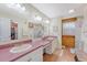 Bathroom featuring dual sinks with pink counters, wood-paneled accent wall and a large mirror for a luxurious feel at 5519 Jefferies Hwy, Walterboro, SC 29488