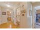 Hallway leading to a bathroom, toilet and living room featuring hardwood floors and natural light at 5519 Jefferies Hwy, Walterboro, SC 29488