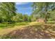Exterior view of cabin showcasing its serene setting amongst mature trees and a tranquil pond at 5519 Jefferies Hwy, Walterboro, SC 29488
