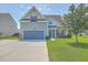 Charming two-story home with a well-manicured lawn, blue garage door, and inviting curb appeal at 575 Rosings Dr, Summerville, SC 29486