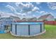 Backyard featuring an above ground swimming pool with deck, surrounded by green grass and a wooden fence at 575 Rosings Dr, Summerville, SC 29486