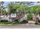 Inviting brick townhome featuring charming white stairs, established trees, and neat landscaping at 622 Windermere Blvd # D, Charleston, SC 29407