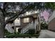 Charming brick townhome with white stairs, lush landscaping, and mature trees, during twilight hours at 622 Windermere Blvd # D, Charleston, SC 29407