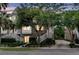 Inviting brick townhome featuring charming white stairs, established trees, and neat landscaping at dusk at 622 Windermere Blvd # D, Charleston, SC 29407