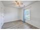 An open bedroom with gray wood flooring, a window with curtains, and a ceiling fan at 7300 Suncatcher Dr, Hanahan, SC 29410