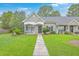 Inviting single-story home with a well-maintained lawn and lovely landscaping at 7300 Suncatcher Dr, Hanahan, SC 29410