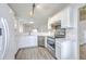 A white kitchen with stainless steel appliances, gray wood flooring, and a bar height countertop at 7300 Suncatcher Dr, Hanahan, SC 29410