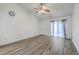 A bright living room with vaulted ceiling, ceiling fan, wood flooring, and sliding glass door with curtains at 7300 Suncatcher Dr, Hanahan, SC 29410