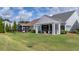 Backyard view of a well manicured lawn featuring two screened-in patios with overhead pergolas at 105 Harbor Trace Ln, Summerville, SC 29486