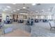 Spacious ballroom with large chandelier lighting, tables and chairs, neutral carpet, and stage, ideal for large gatherings at 105 Harbor Trace Ln, Summerville, SC 29486