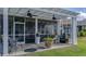 A screened-in patio with tiled floor, ceiling fans, furniture, and flower pots overlooks the well-manicured lawn at 105 Harbor Trace Ln, Summerville, SC 29486