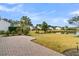 A lush green lawn extends to a serene pond, complemented by palm trees at 109 Billowing Sails St, Summerville, SC 29486