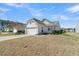 Charming white home featuring an attached two-car garage, manicured landscaping and partial view of a lake at 109 Billowing Sails St, Summerville, SC 29486