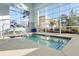 Relaxing indoor hot tub with tiled walls and large windows bringing the outdoors in for year-round enjoyment at 109 Billowing Sails St, Summerville, SC 29486