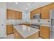 Well-lit kitchen includes an island, stainless steel appliances, tile backsplash, and countertops at 109 Billowing Sails St, Summerville, SC 29486