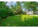 Expansive backyard featuring lush green grass, mature trees, and a storage shed at 114 Bailey Dr, Summerville, SC 29485
