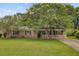 Charming brick home featuring a well-manicured lawn and beautiful, mature trees at 114 Stewart St, Goose Creek, SC 29445