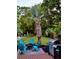 Outdoor entertaining area featuring a grill, a fire pit, and seating, all surrounded by lush greenery at 1145 Bellwood Rd, Charleston, SC 29412