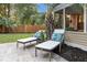 Inviting backyard with a stone patio, two lounge chairs, and a decorative palm tree at 1145 Bellwood Rd, Charleston, SC 29412