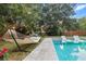 Inviting backyard pool featuring sleek lounge chairs, a comfy hammock, and lush landscaping at 1145 Bellwood Rd, Charleston, SC 29412